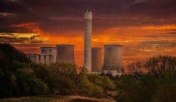 Power plant with orange sky in background|dominik vanyi unsplash