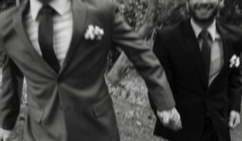 Two men in suits holding hands