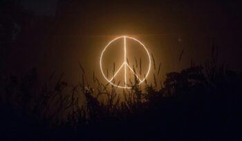 Peace sign lit in the sky at night