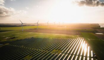 Solar farm and wind turbines on sunny day