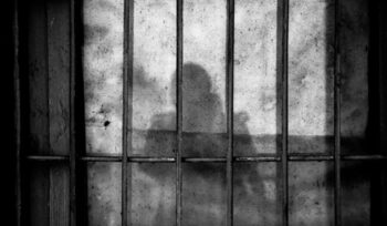 Silhouette behind prison bars